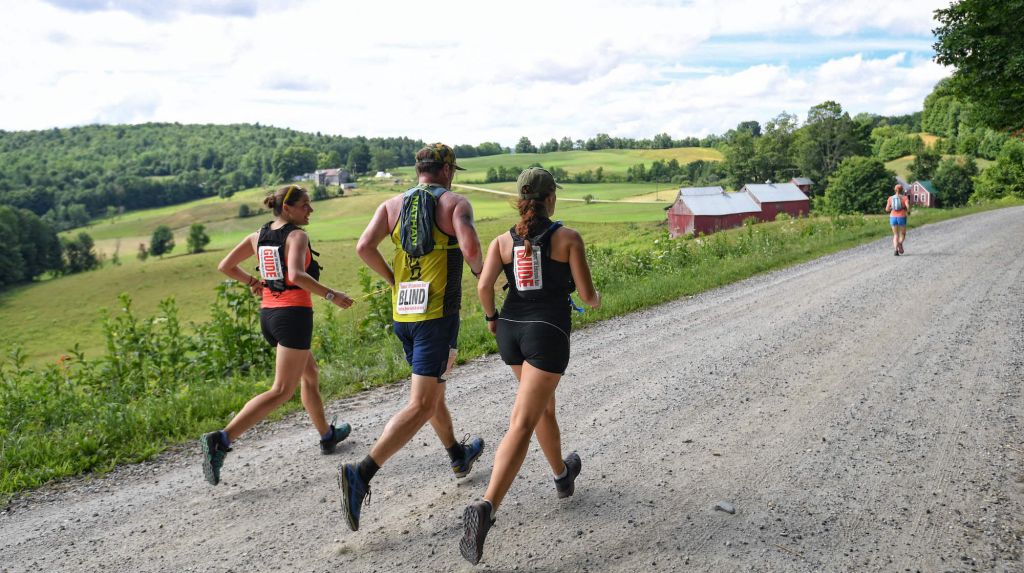 Amy (left) guiding visually impaired athlete Kyle Robidoux (center) with another guide (right) on the Vermont 100 course