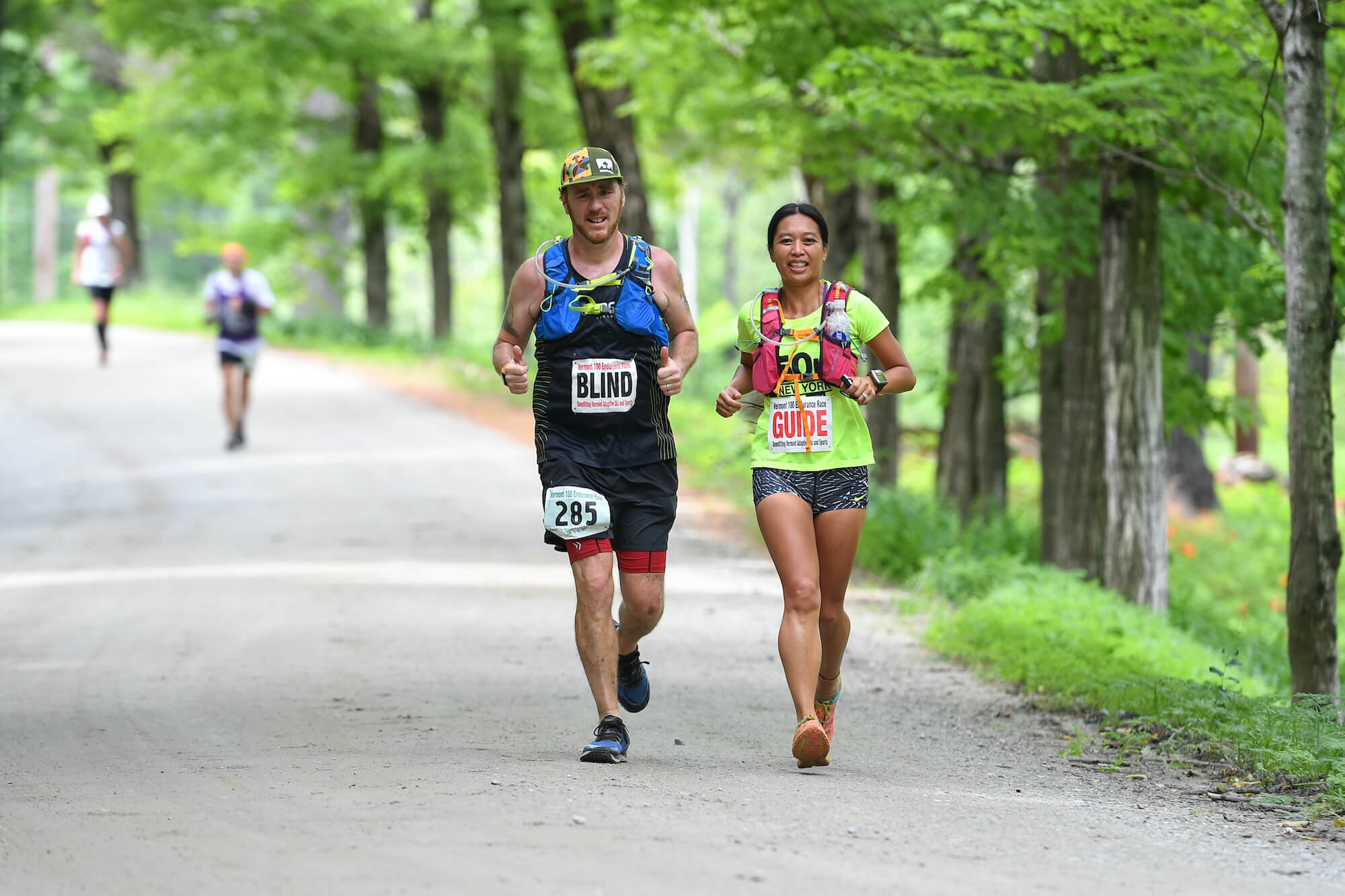 A visually impaired athlete and their guide running on the VT100 course.